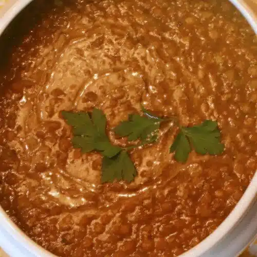 Overhead golden bowl topped with flat-leaf parsley on a yellow cloth