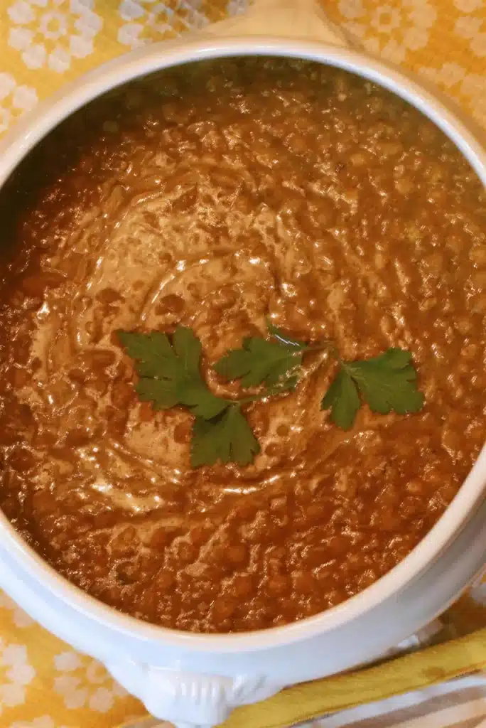 Overhead golden bowl topped with flat-leaf parsley on a yellow cloth
