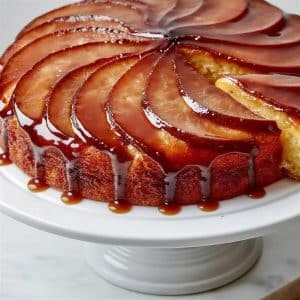 Pear upside down cake with slices fanned in a spiral under dark caramel