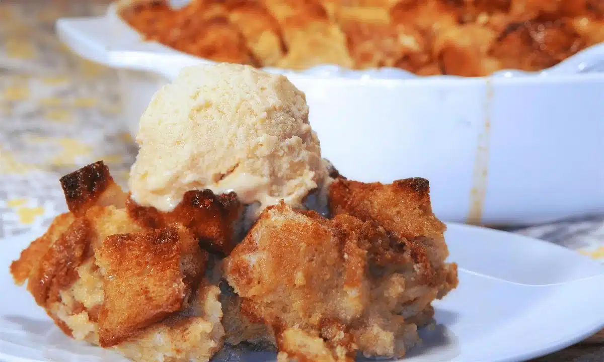 Persimmon bread pudding served with a scoop of ice cream melting over it