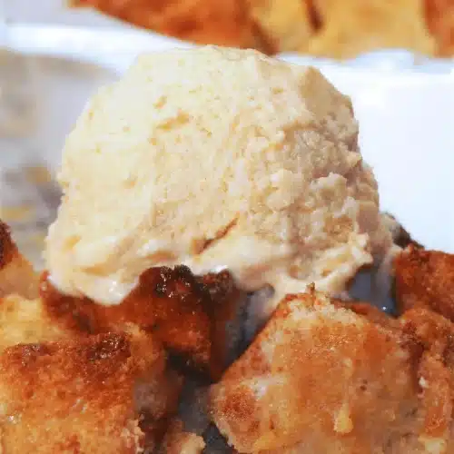 Persimmon bread pudding topped with a scoop of vanilla ice cream