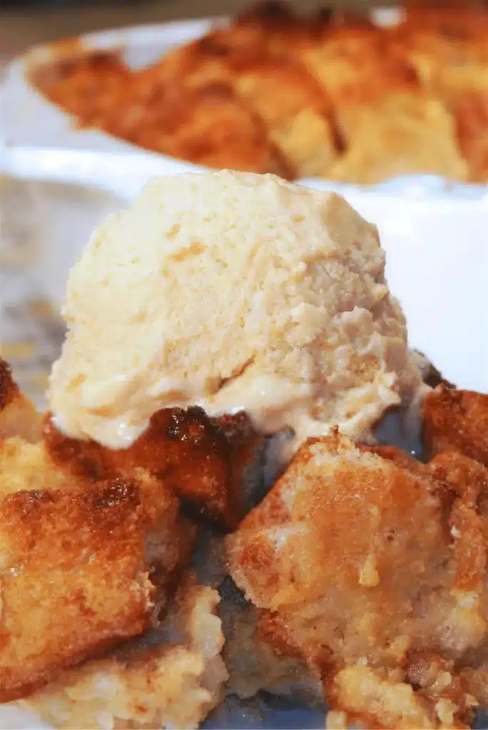 Persimmon bread pudding topped with a scoop of vanilla ice cream