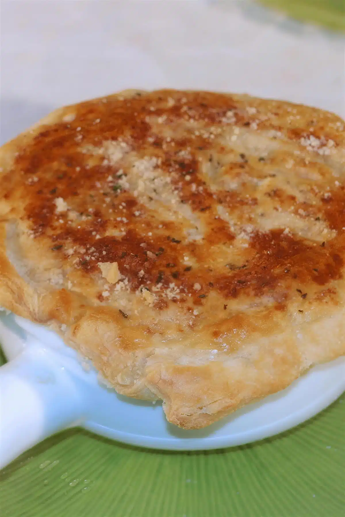 Turkey pot pie in a white dish with a puffed golden crust
