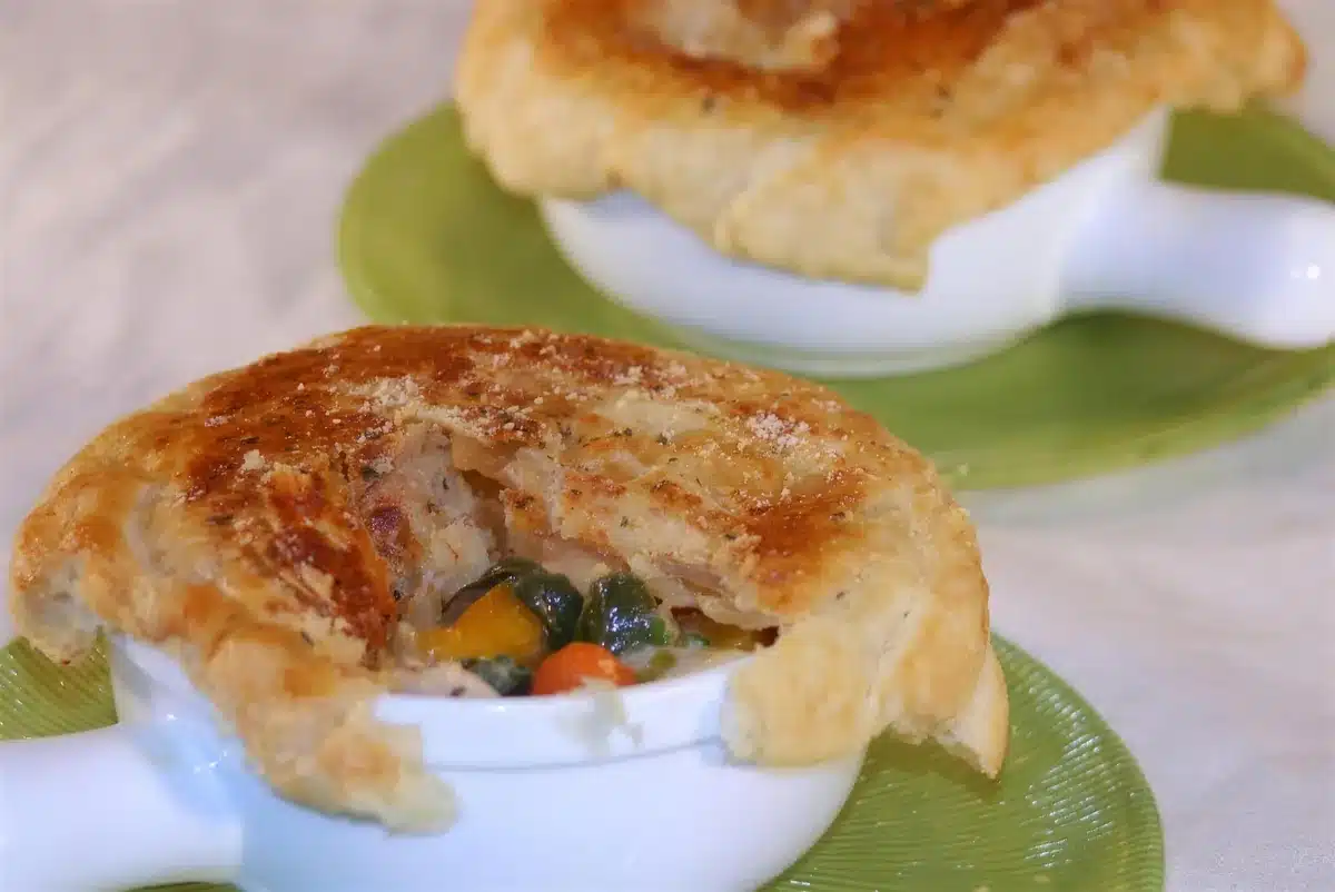 Turkey pot pie broken open to show carrot squash and peas in a creamy sauce