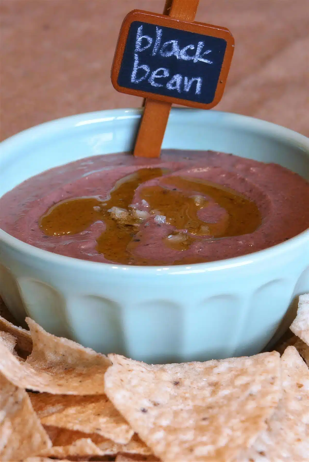 Pale blue ramekin with a chalkboard tag and tortilla chips