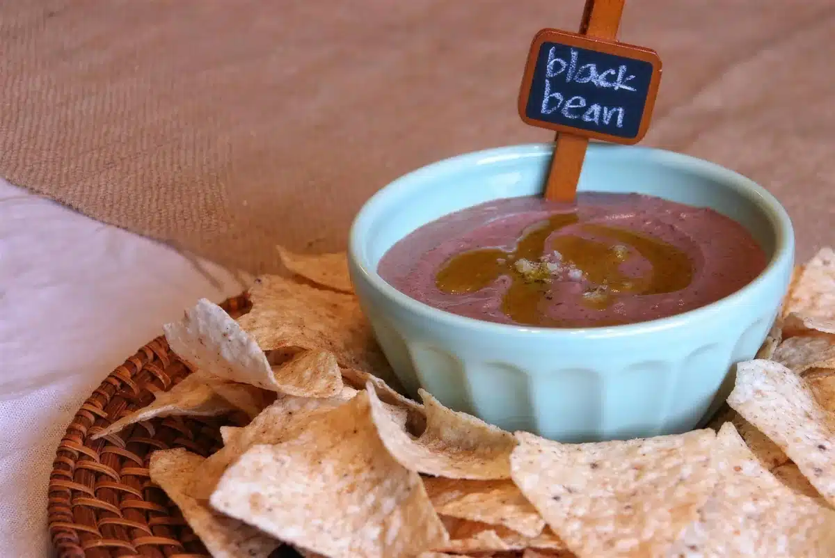 Black bean hummus in a ramekin swirled with green salsa