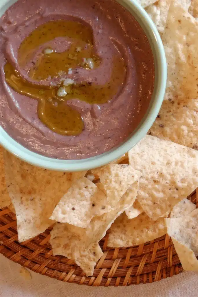Overhead pale bowl of smooth spread ringed with tortilla chips