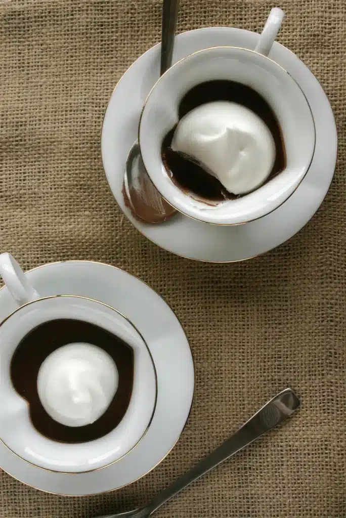 Close view of a whipped cream dollop on a set dark custard