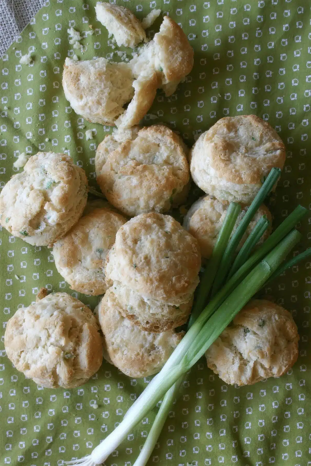 Warm golden rounds on a green cloth beside a whole spring onion