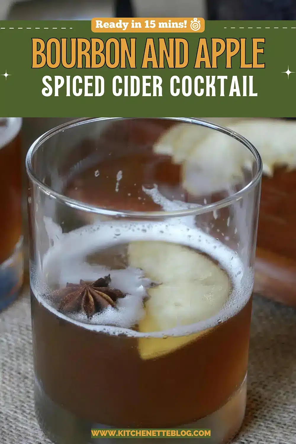 Amber drink in a short glass with a floating apple slice and star anise
