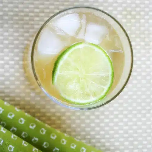 Overhead view of a chilled drink with a lime wheel resting on the ice