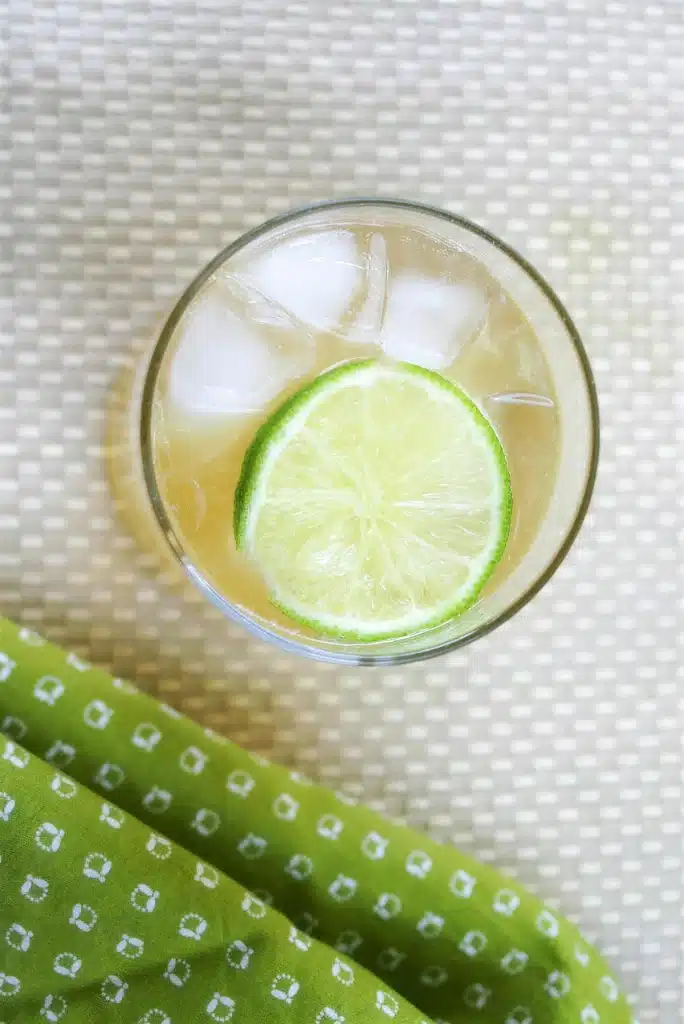 Overhead view of a chilled drink with a lime wheel resting on the ice
