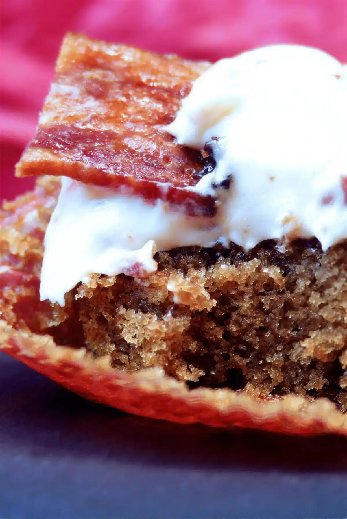 Cream cheese frosting and a shard of crisp pork on a split cake