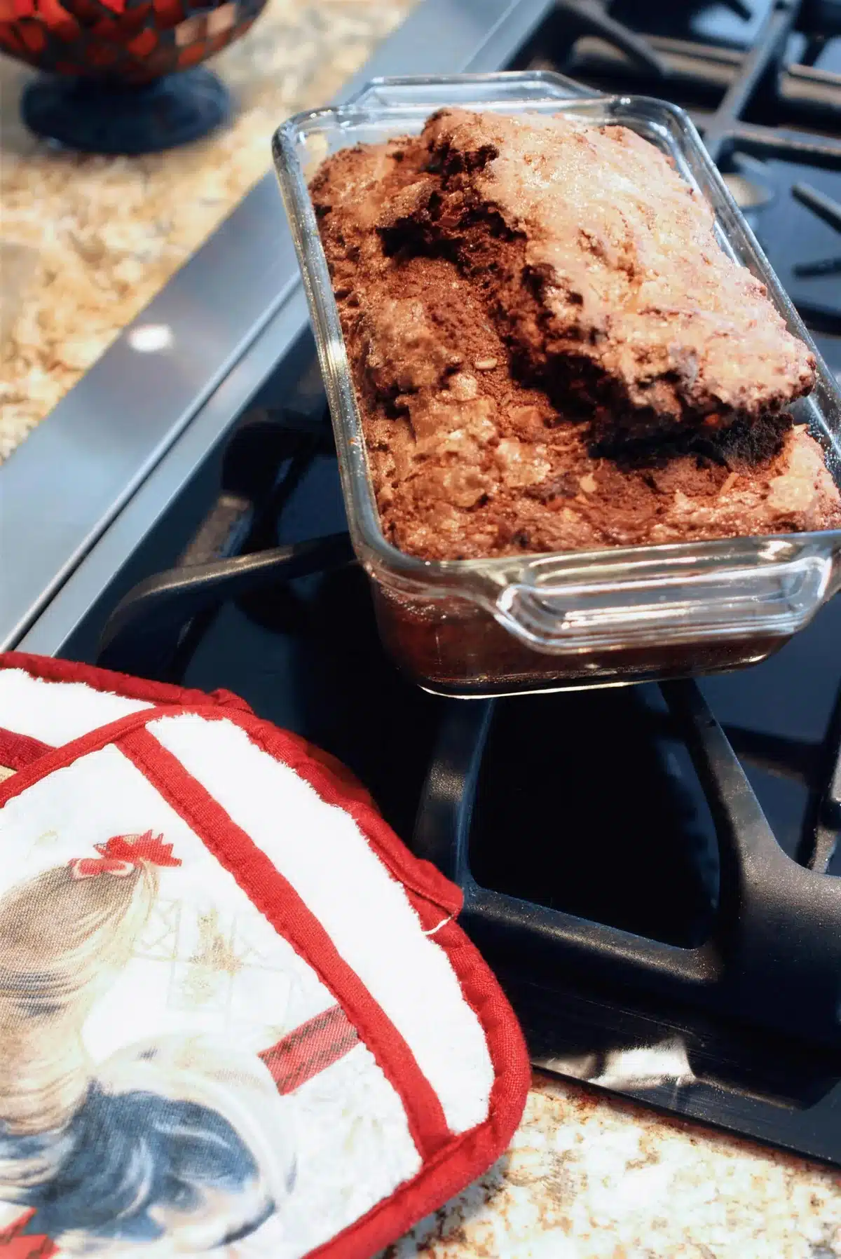 A glass loaf pan just out of the oven on the stovetop