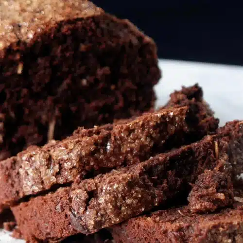 Coconut banana bread cut into thick slices on a striped cloth