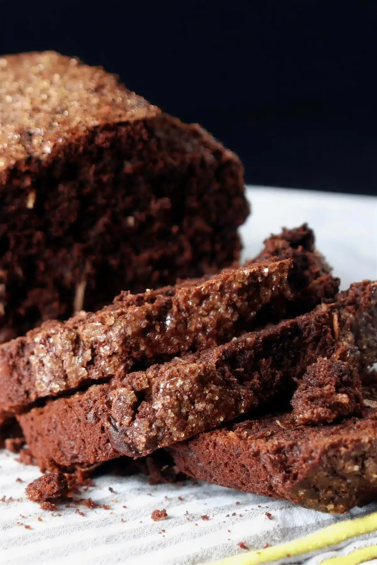 Coconut banana bread cut into thick slices on a striped cloth