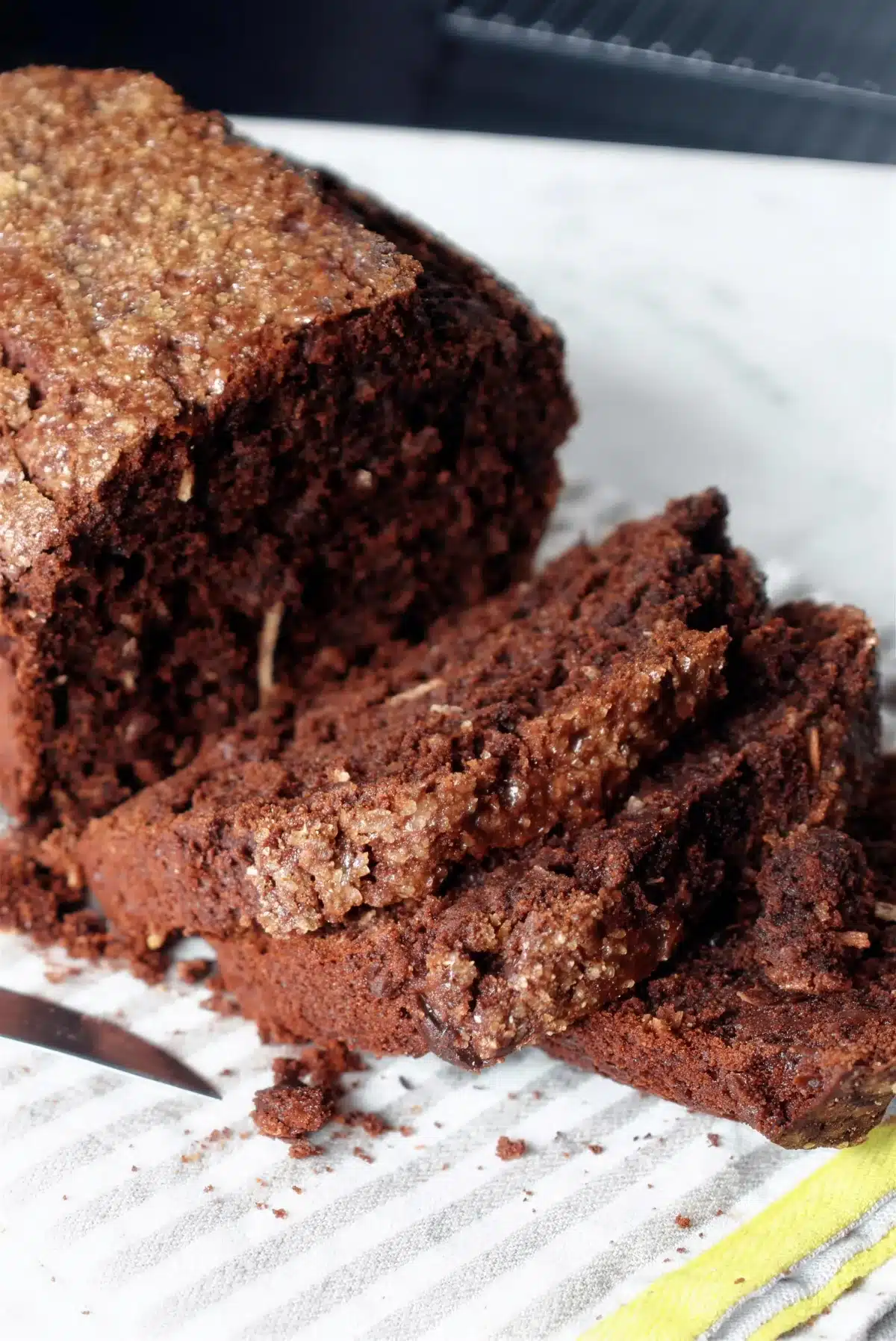 Coconut banana bread cut open on white marble