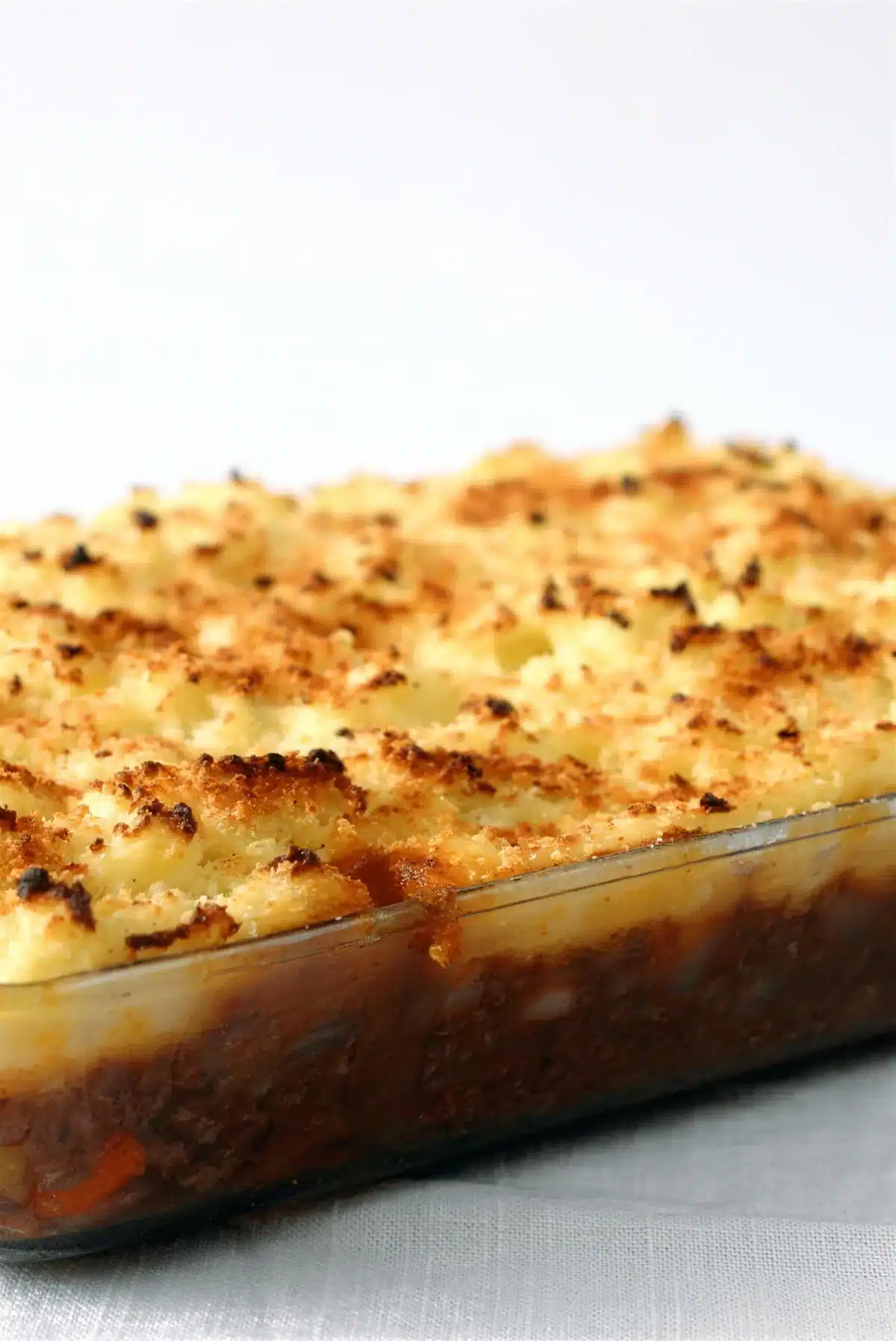 Shepherds pie baked in a glass dish with a browned crumb crust