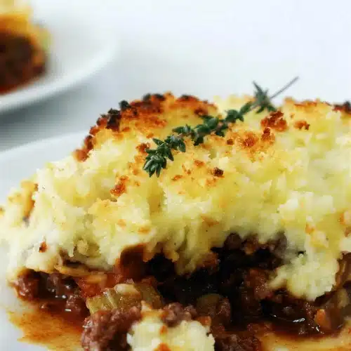 Shepherds pie served on a plate with the mash cut open