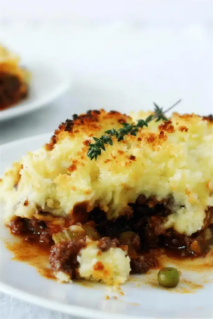 Shepherds pie served on a plate with the mash cut open