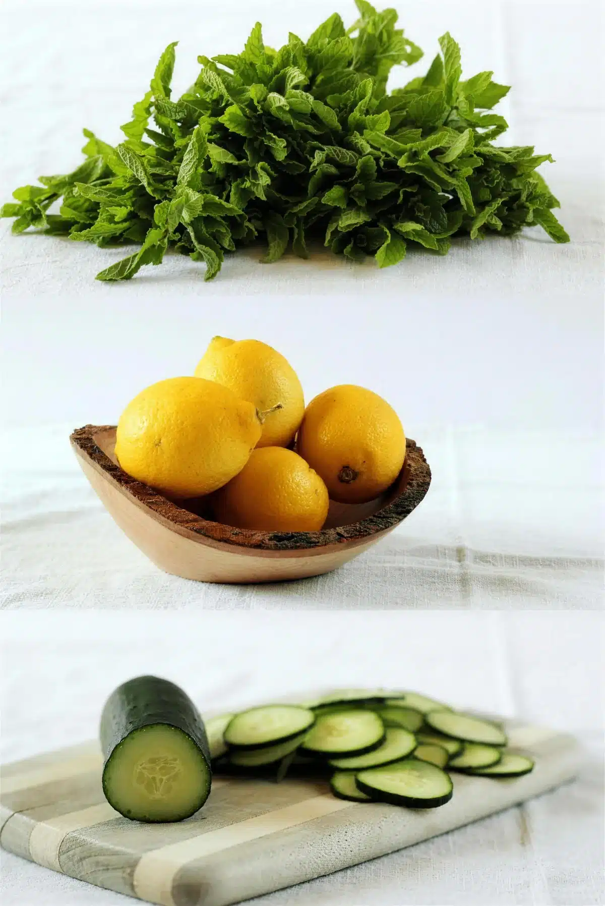 Fresh mint, whole lemons in a wooden bowl and thin cucumber slices on a board