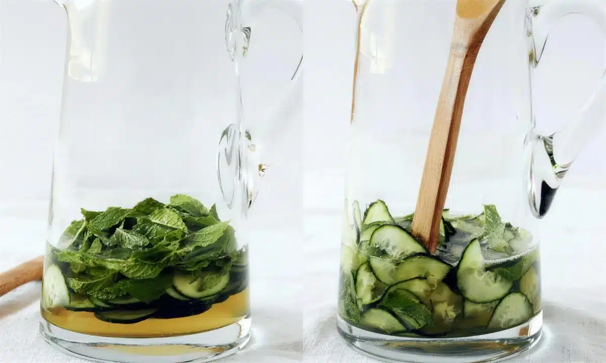 Two glass jugs with cucumber and torn mint at the muddling stage