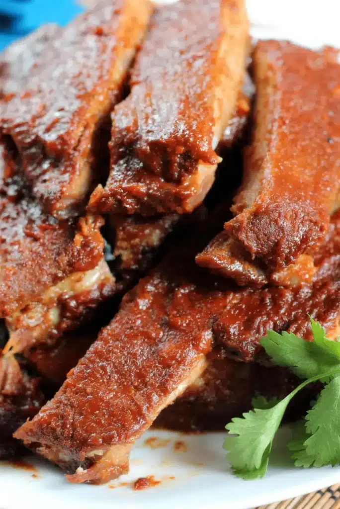 Close view of sliced glazed pork on a white plate with cilantro