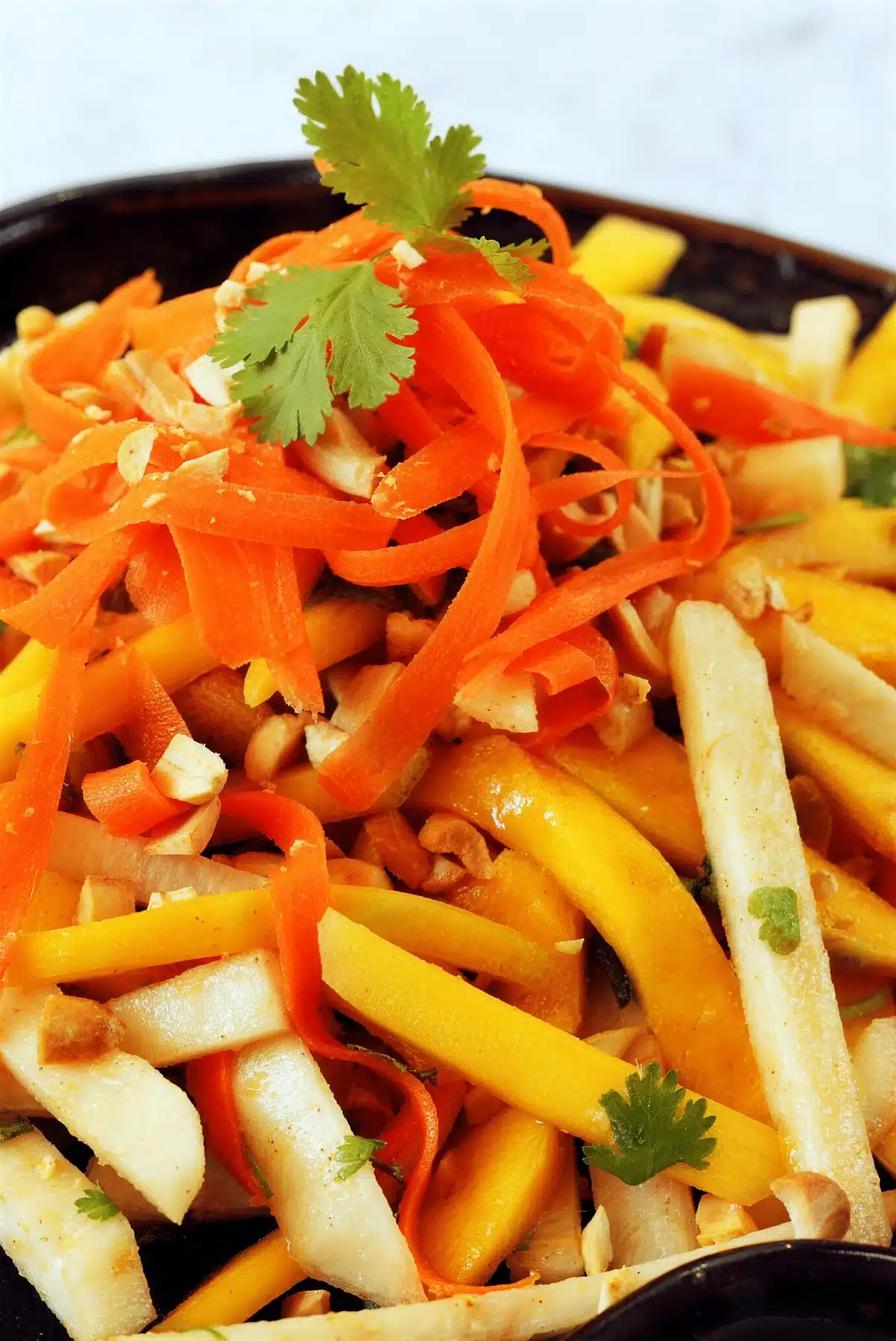 Jicama salad close up with carrot ribbons and chopped peanuts