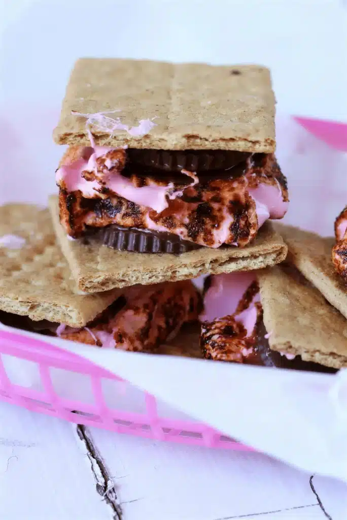 A toasted marshmallow sandwich stacked on white painted boards