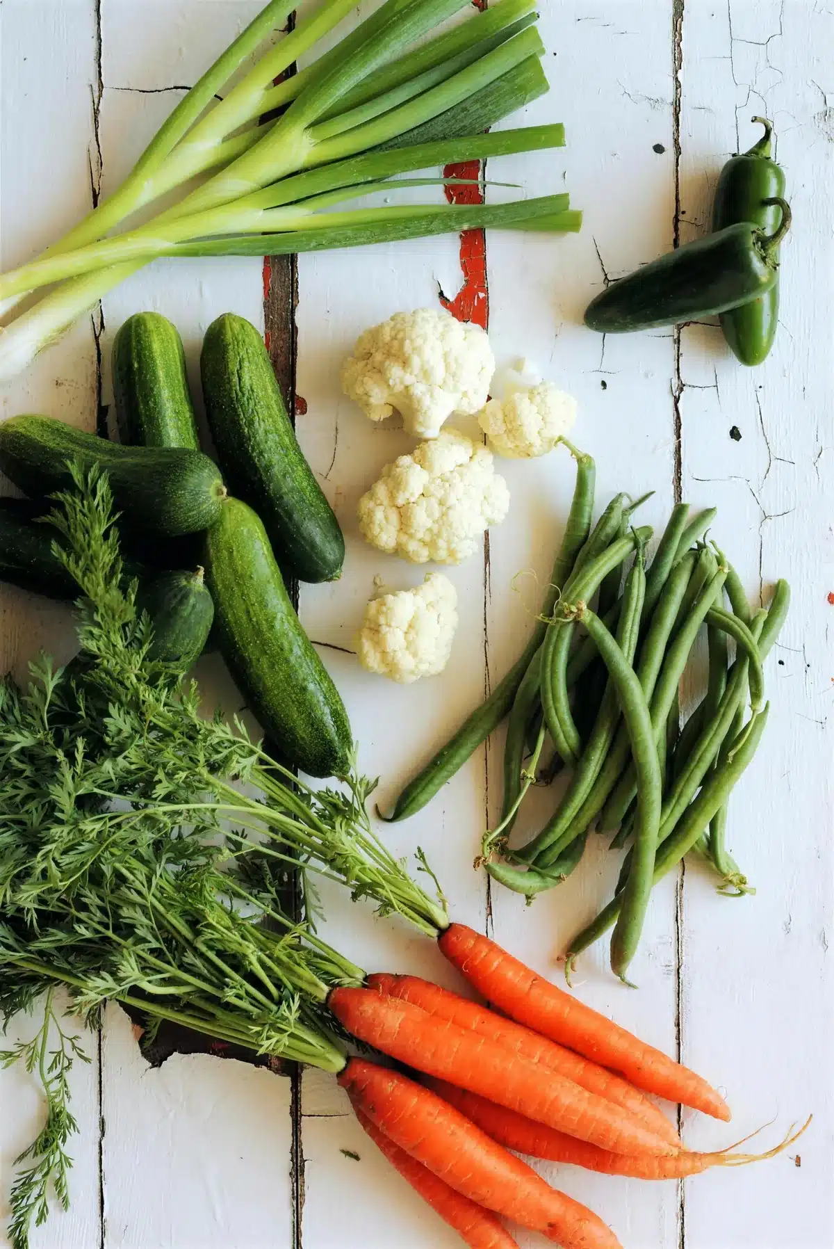 Vegetables laid out on white boards before they are pickled