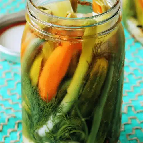Pickled vegetables packed tightly into a quart jar with dill