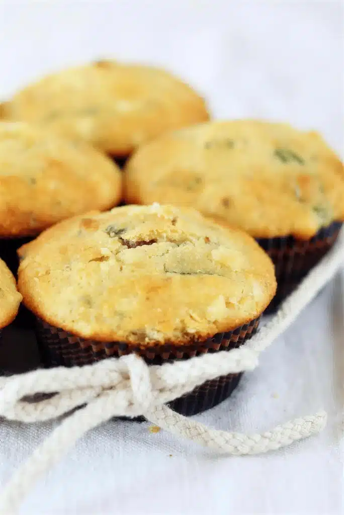 A tray of golden baked goods in dark paper liners tied with a cotton cord