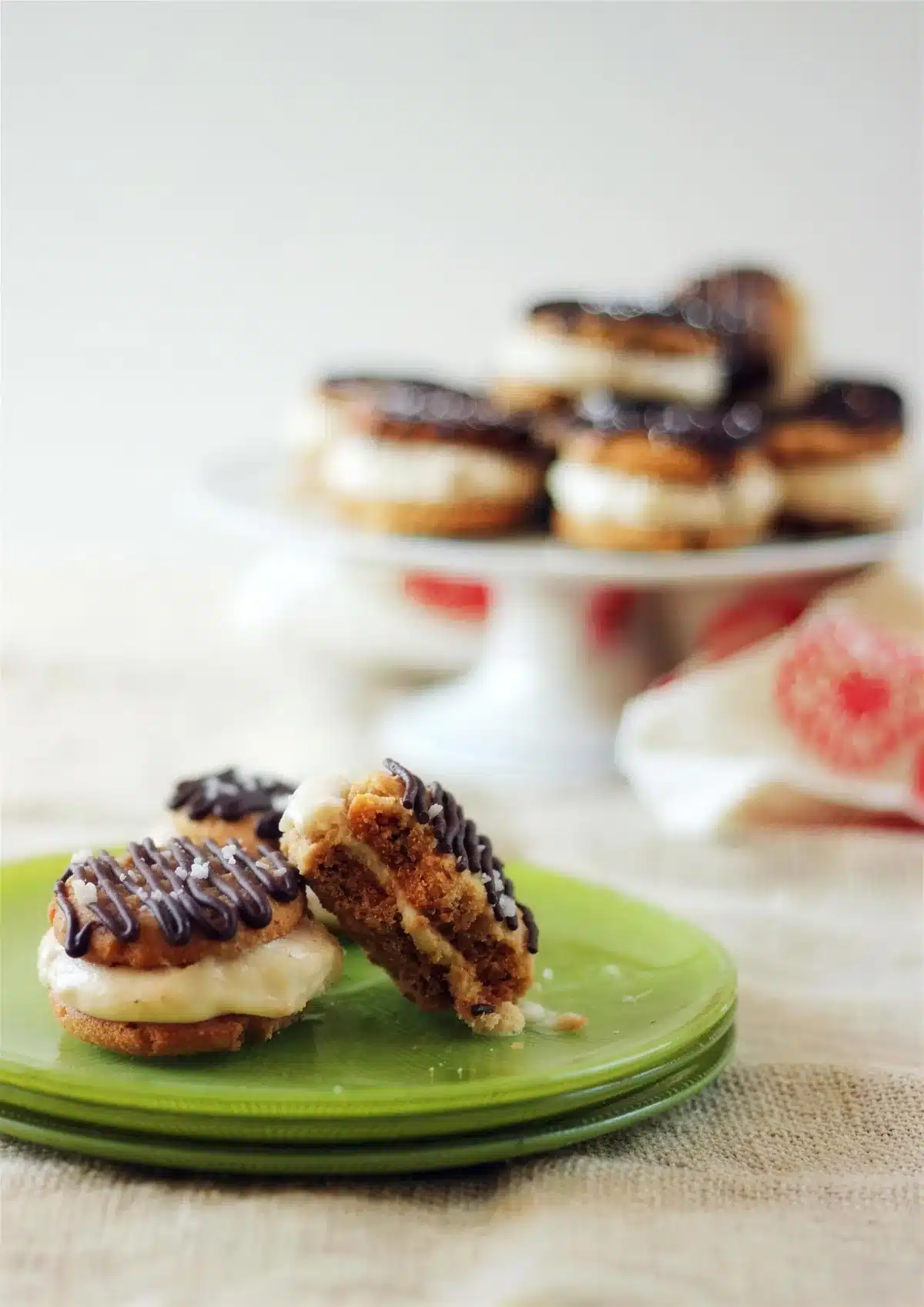 Peanut butter banana ice cream sandwiches, one cut in half on a green plate