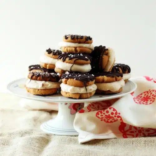 Pyramid of frozen cookie rounds on a white cake stand with a red cloth