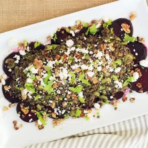 Beet lentil salad on a white platter seen from above