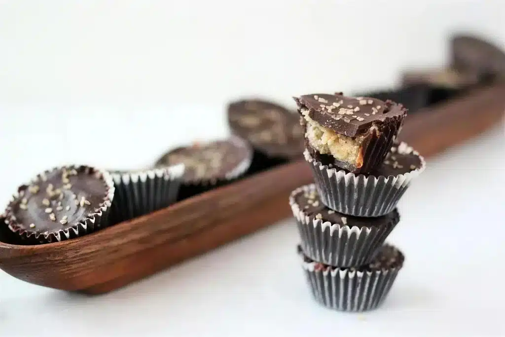A chocolate candy cut in half to show the pale filling and a darker caramel band
