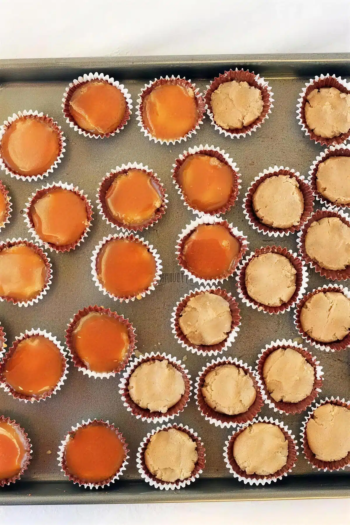 Amber bourbon caramel spooned over the pale filling in each chocolate shell