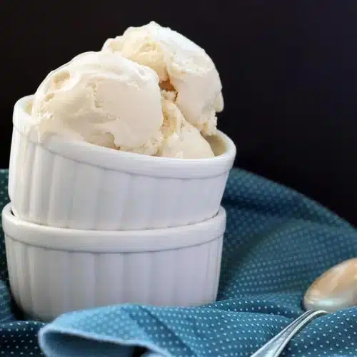 Homemade frozen yogurt scooped into stacked ramekins on a blue polka dot cloth
