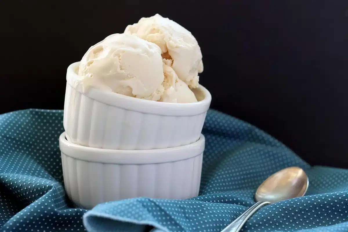 Homemade frozen yogurt scooped into stacked ramekins on a blue polka dot cloth