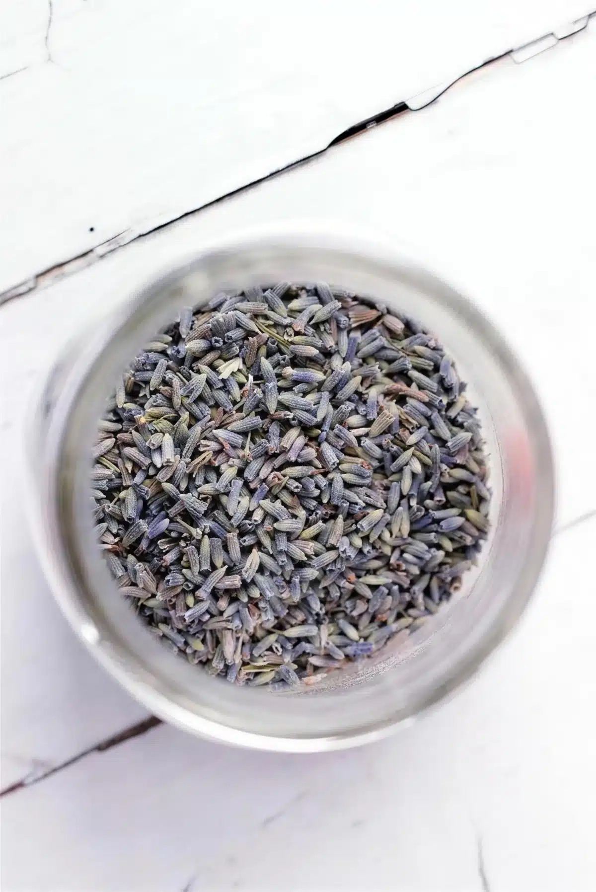Overhead view of dried lavender buds in a small metal bowl
