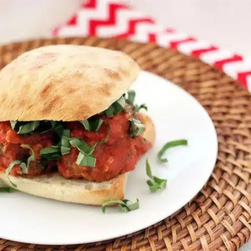 Toasted ciabatta roll piled with saucy spheres and shredded basil
