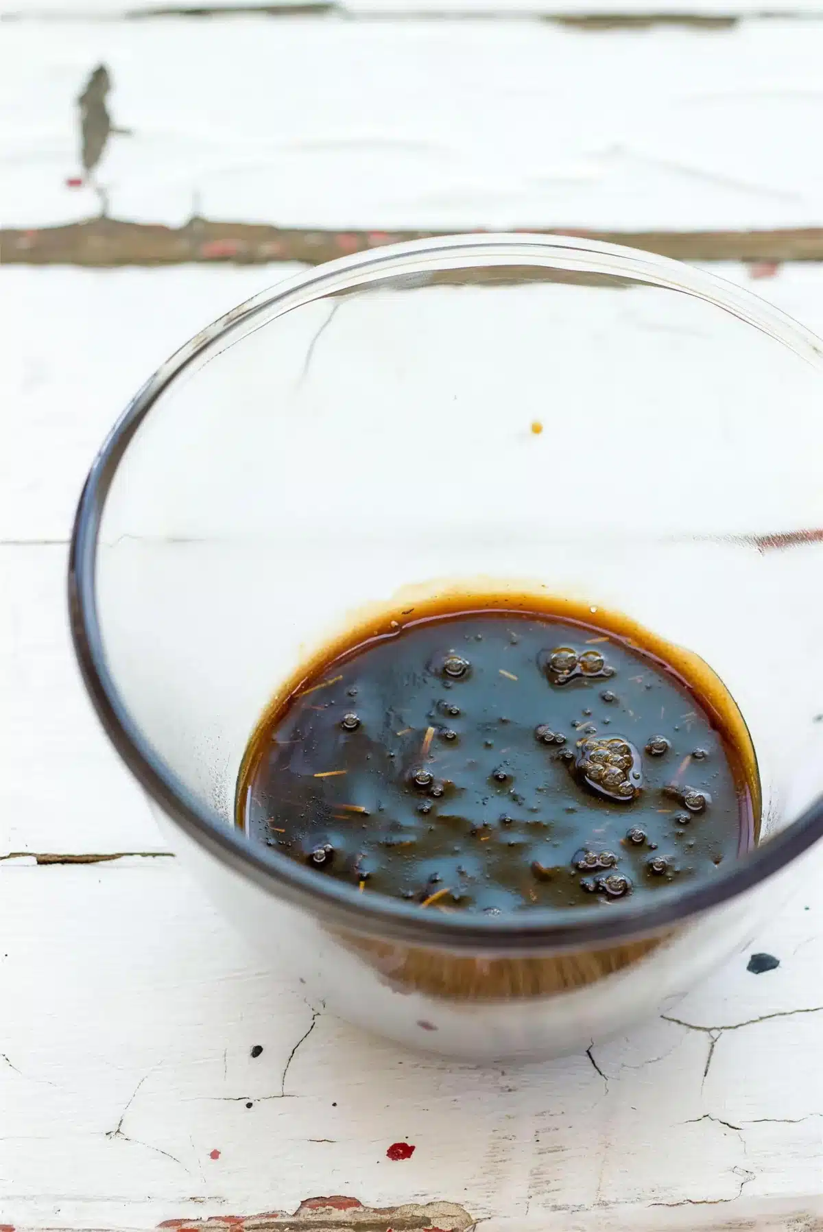 Dark fruit syrup reducing to a thick coat in a small pot
