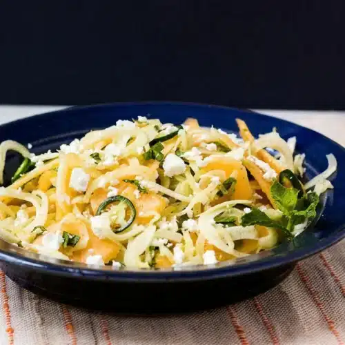 Shaved fennel salad with feta and mint in a dark blue bowl
