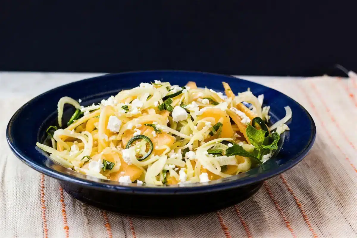 Shaved fennel salad with feta and mint in a dark blue bowl