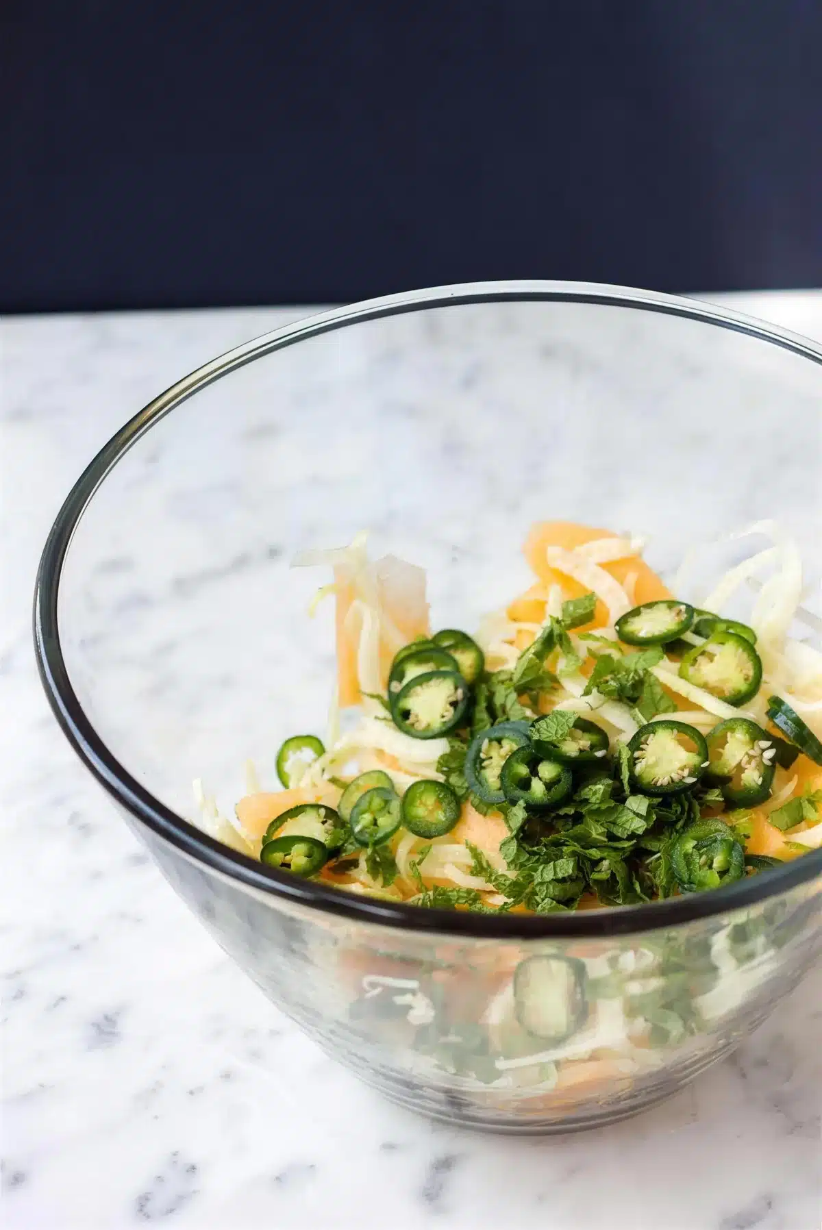 Shaved fennel salad in a glass bowl before the dressing goes on