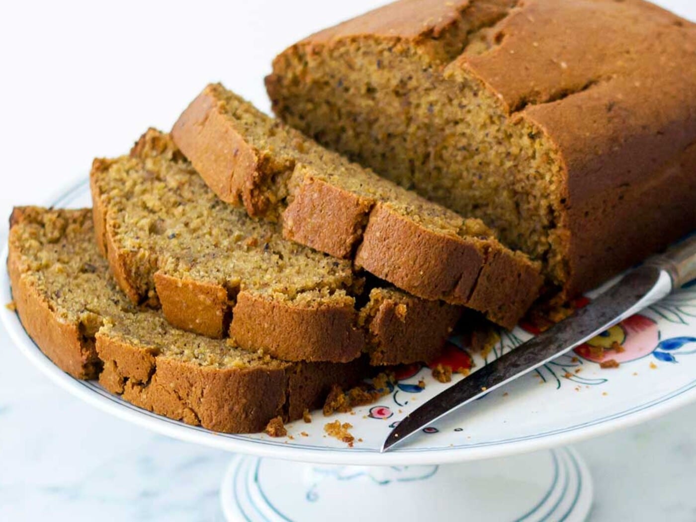 Thick slices of pumpkin beer bread leaning against the cut end of the loaf