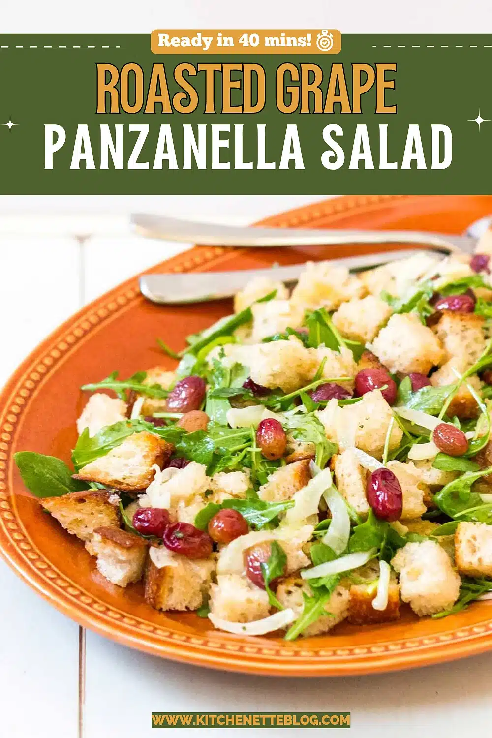 Terracotta plate of torn bread, arugula and red grapes with a serving fork