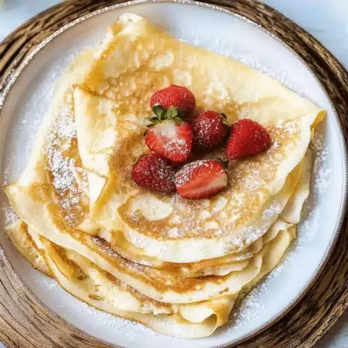 Stack of folded thin pancakes on a woven charger with white flowers