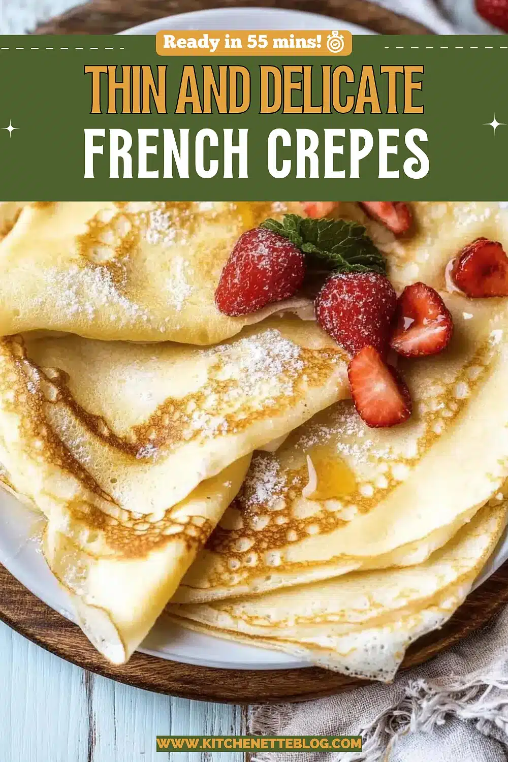 Folded thin pancakes dusted with sugar and topped with strawberries