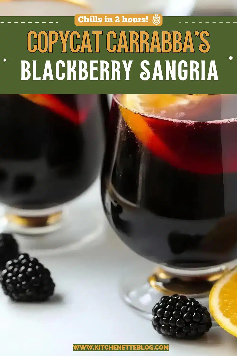 Two stemmed glasses of dark red wine punch with citrus wheels and berries